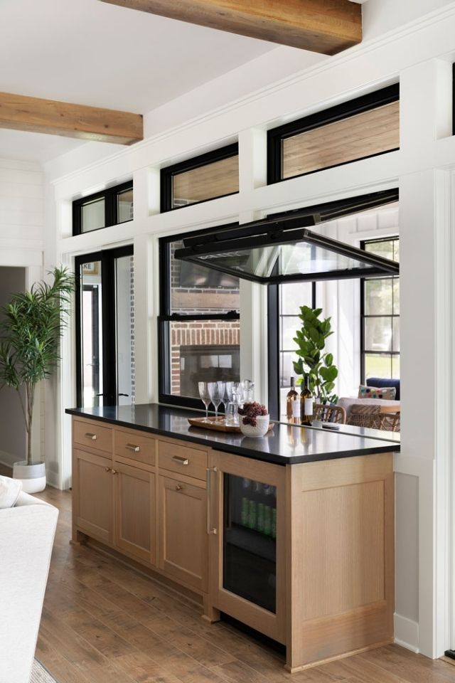 Natural wood bar open to the outdoor entertaining space in modern lake home
